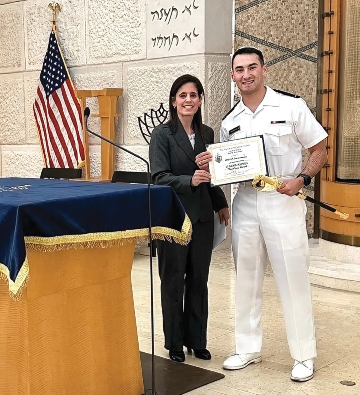Devora Kirschner presents the LT Darin Pontell Memorial Sword to ENS Sam Zimmerman ’26, USN, during the 2026 Jewish Baccalaureate
